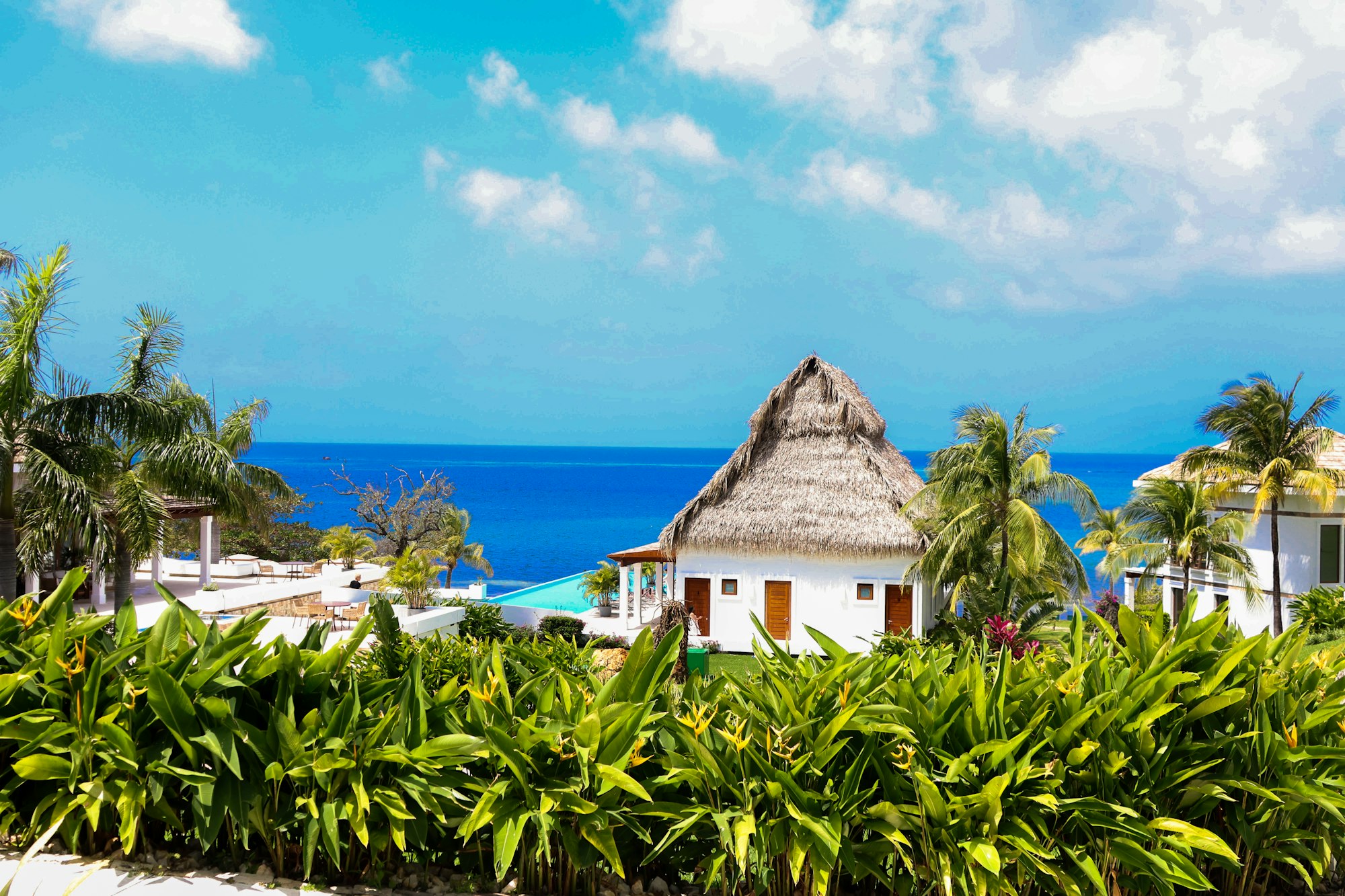 Thatched-roof villa beside the turquoise Caribbean in Tulum